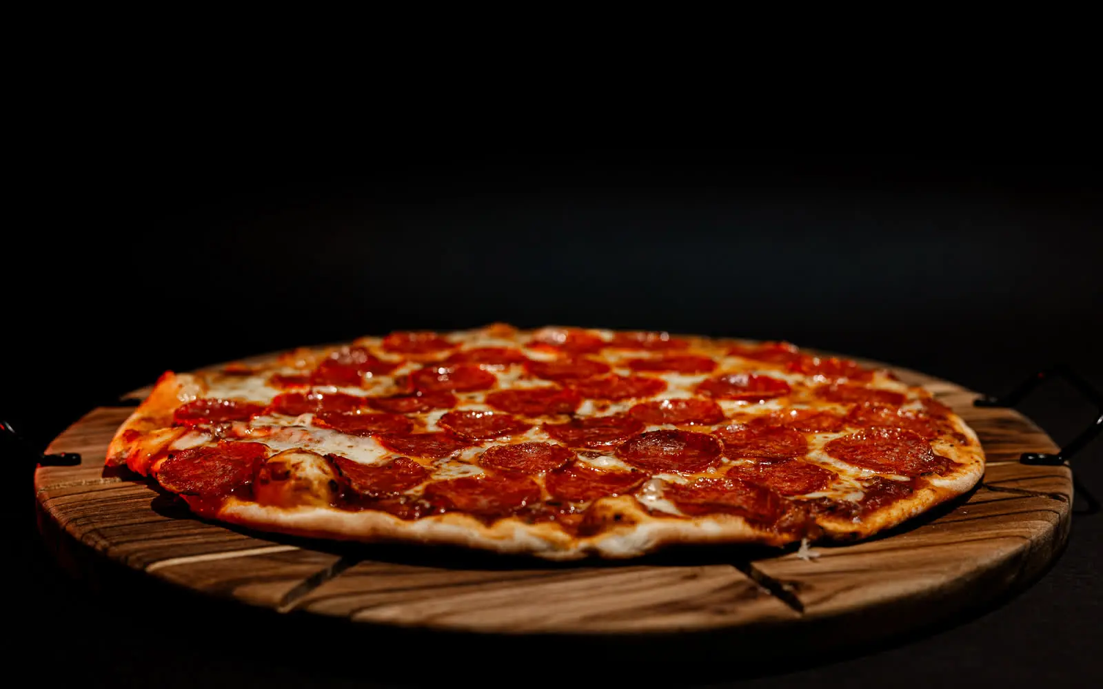 Pizza STECA sobre uma tábua, sob luz baixa.
